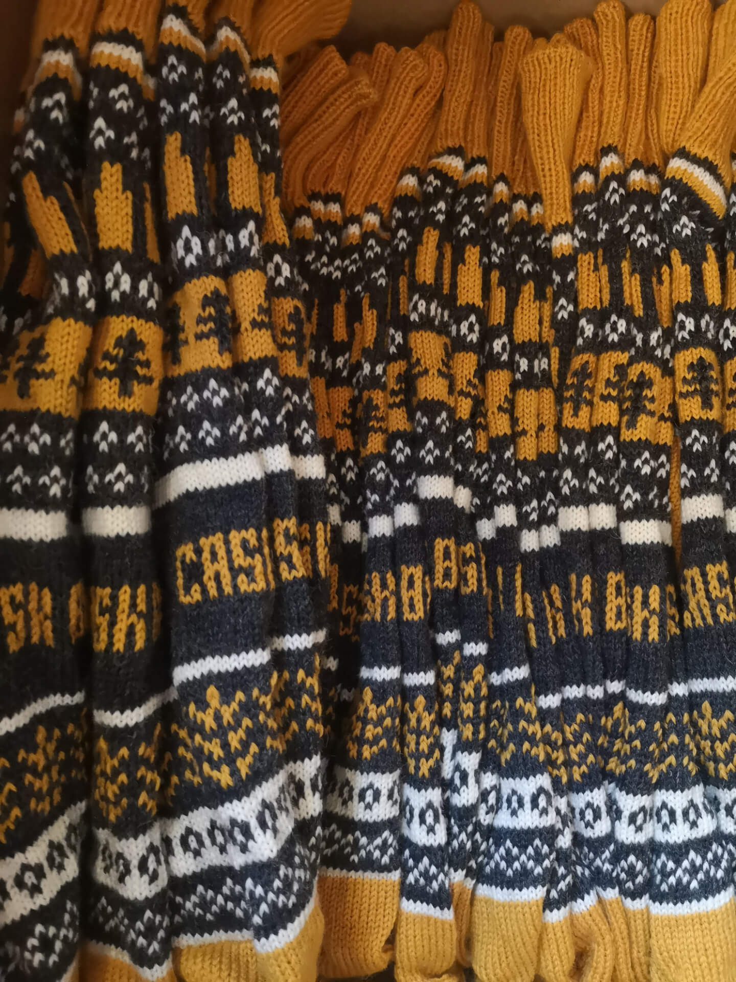 A selection of grey, white, and mustard yellow Fair Isle knitted socks by K.Moods
