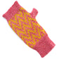 A fingerless glove by K.Moods, it is pink with a yellow thick zig-zag pattern, and sits on a white background. 