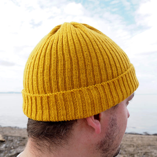 Side view of a man wearing a yellow ribbed beanie by K.Moods.