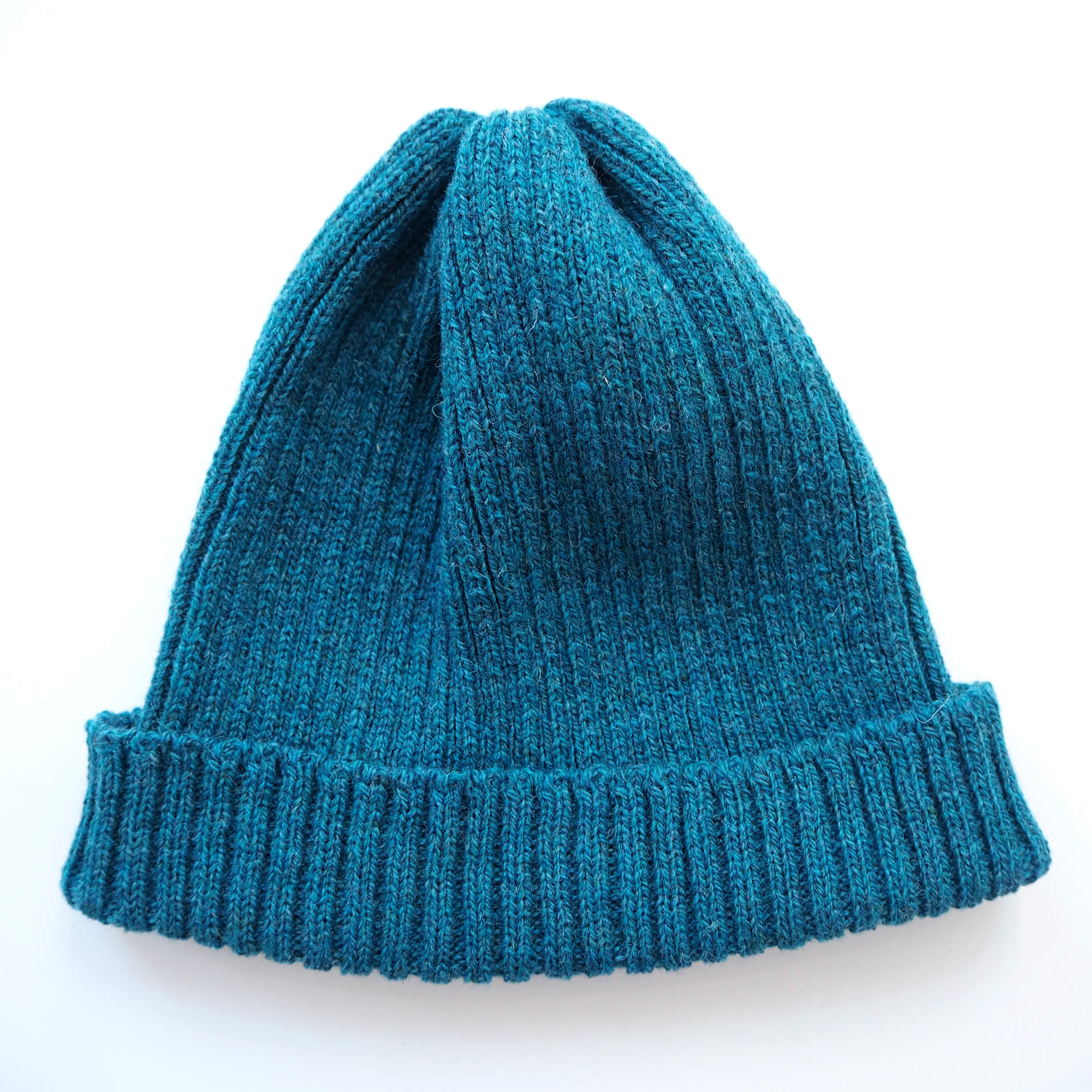 A blue ribbed beanie with a folded brim by K.Moods, on a white background.